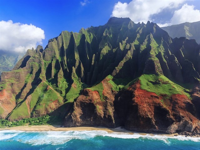 Na Pali Coast On the island of Kauai, also known as the Garden Isle, you can explore the famed Na Pali Coast. Along the coast, sheer cliffs covered in lush, green v...